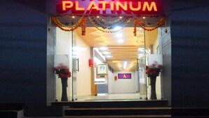 L’entrée de l’hôtel Platinum, avec un comptoir de réception et une enseigne au-dessus.