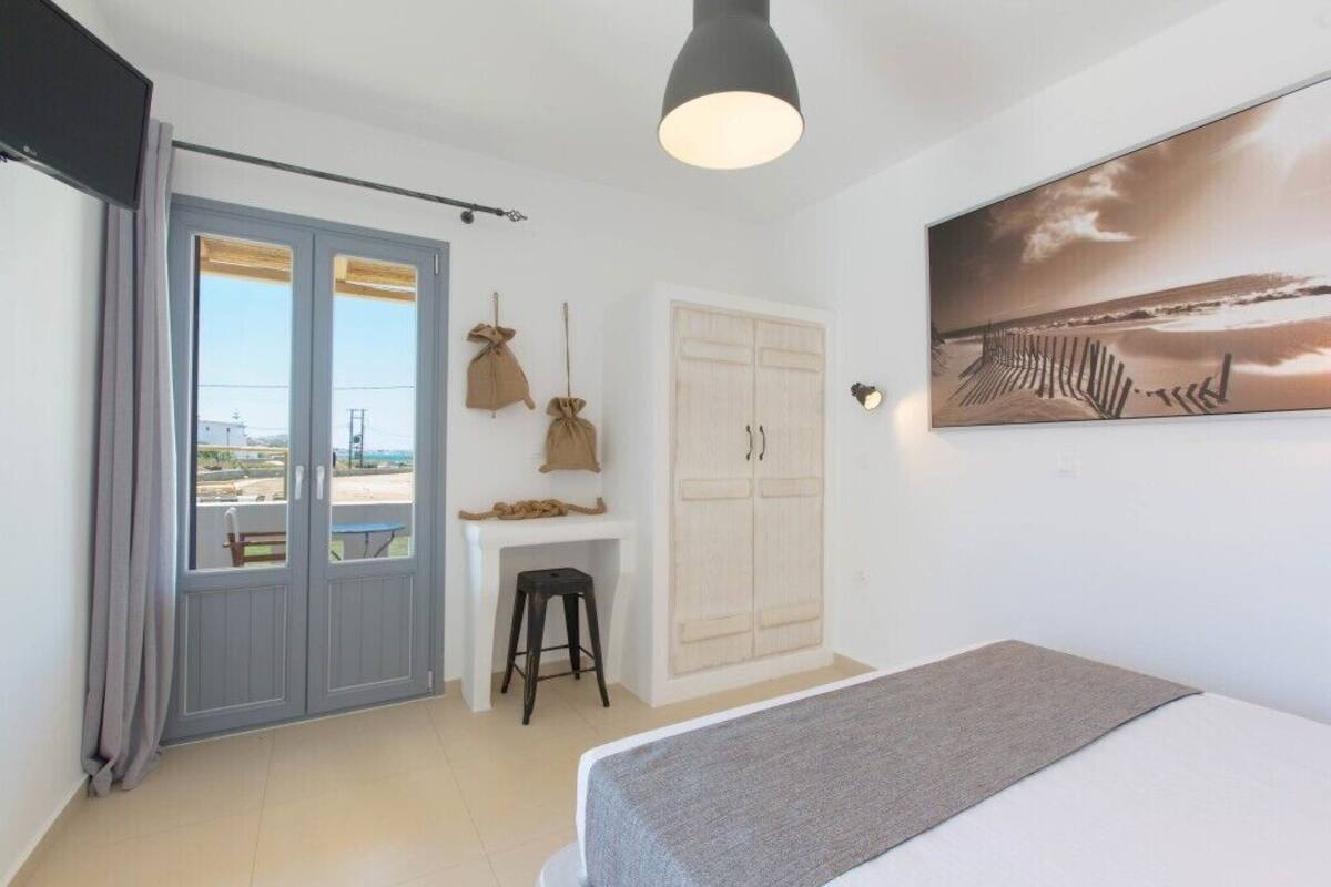 A bedroom with a bed, a desk, and a wardrobe.