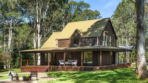 A two-story wooden house with a porch, surrounded by trees. - Ellendale - enjoy the serenity (Kurmond)