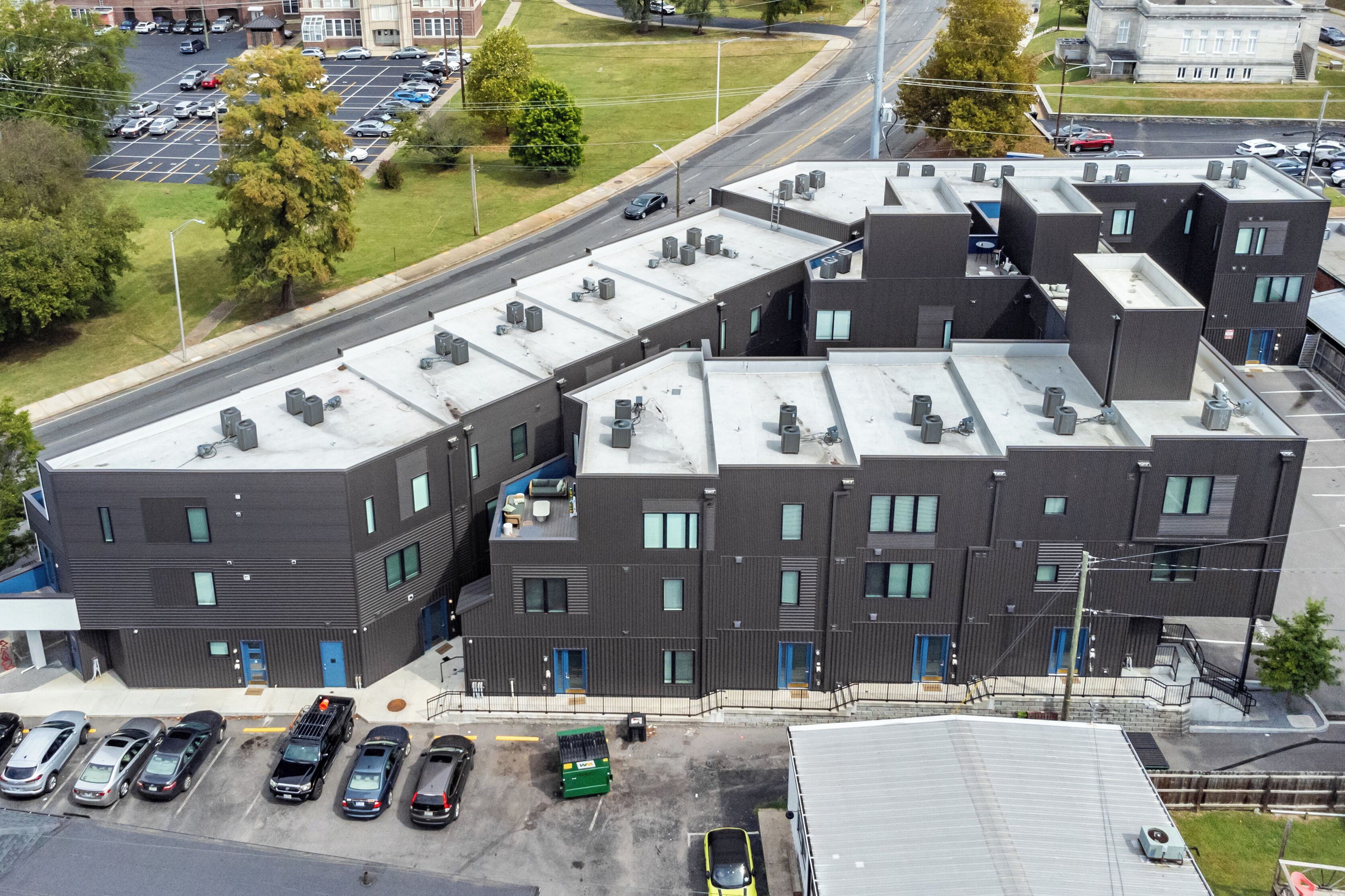 A multi-story building with a parking lot in front.