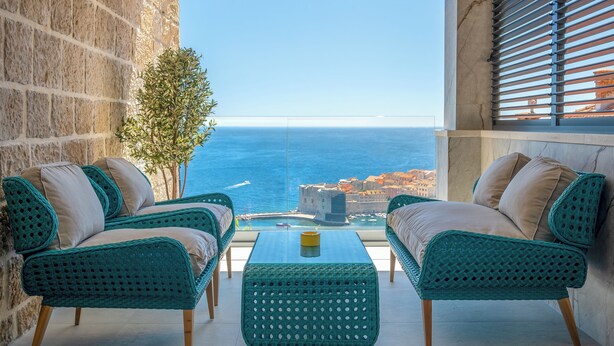 A balcony with two wicker chairs, a small table, and a view of the sea. - Old City Viewpoint by Dubrovnik view (Dubrovnik)