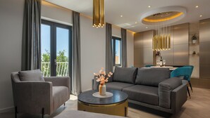 A modern living room with a grey sofa, a round coffee table, and a dining area with a table set for two. - Old City Viewpoint by Dubrovnik view (Dubrovnik)