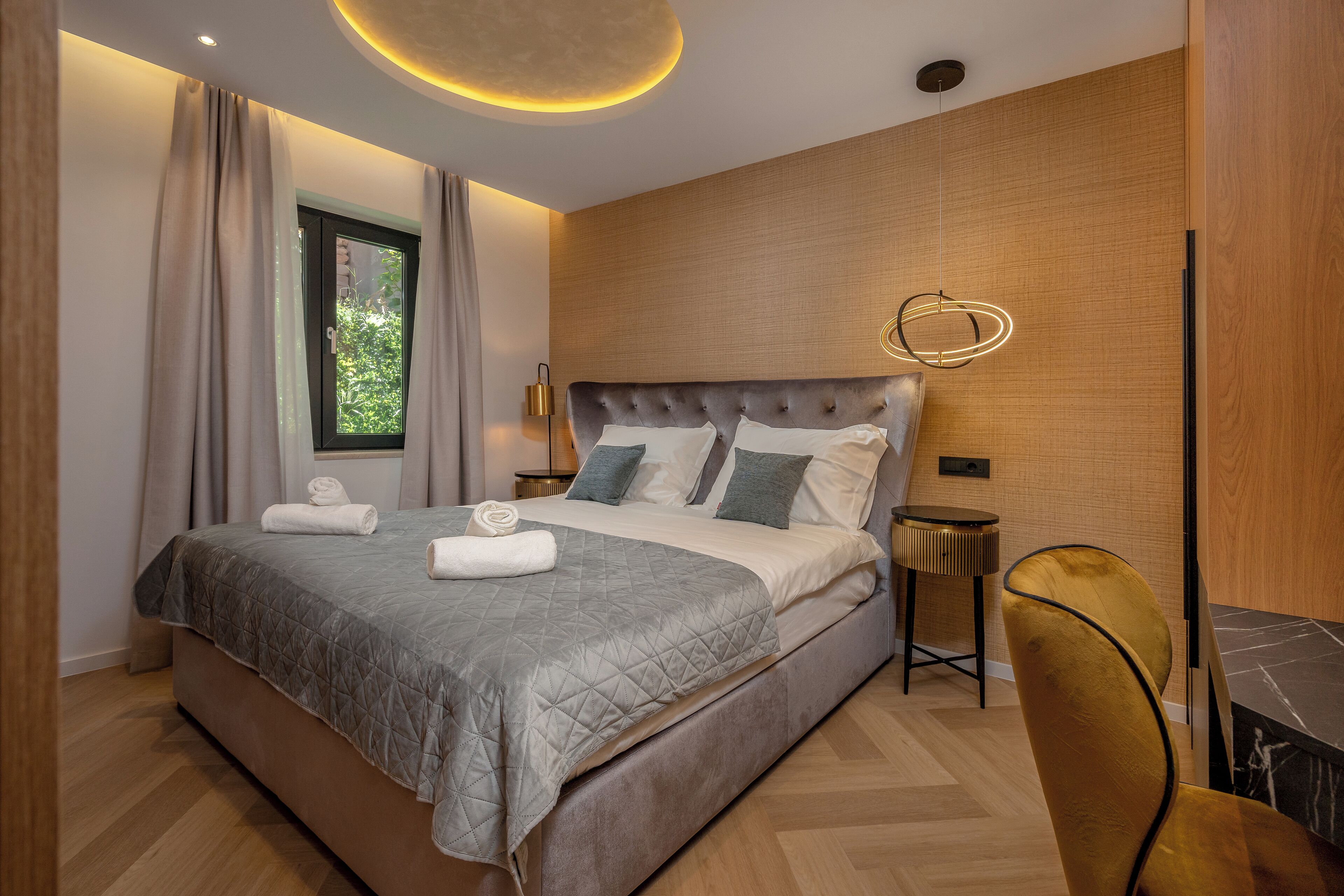 A modern bedroom with a large bed, a round table, and a chair.