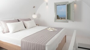 Un dormitorio moderno con una cama grande, una mesita de noche, un buró, una ventana con vistas despejadas y una lámpara de pared.