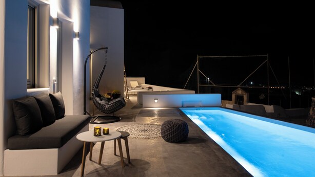 Un espacio exterior moderno con piscina, asientos y una mesa de comedor.