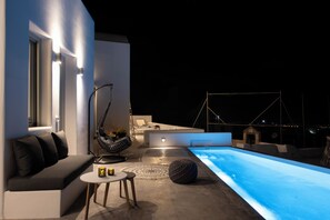 Un espacio exterior moderno con piscina, asientos y una mesa de comedor.