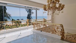 A spacious balcony with a clear view of the sea, a decorative chandelier, and ornate metal railings. -  Ruby Hotel Phan Thiet (Tien Thanh)