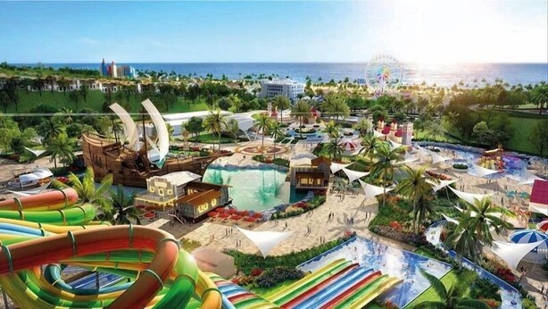 A resort with a large water park, including slides and a wave pool, surrounded by palm trees and a view of the ocean. -  Ruby Hotel Phan Thiet (Tien Thanh)