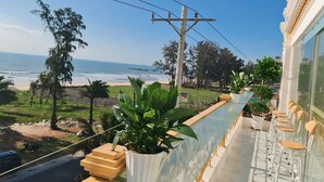 A balcony with a view of the beach, power lines, and a potted plant. -  Ruby Hotel Phan Thiet (Tien Thanh)