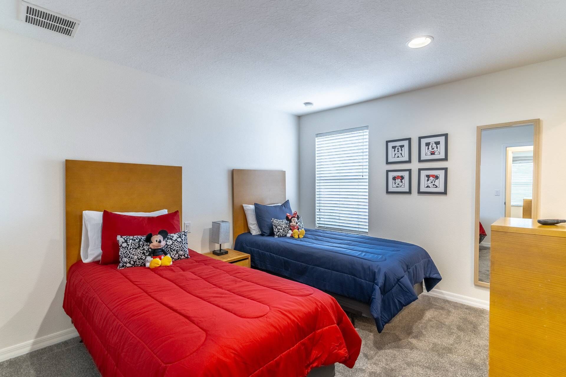Une chambre d’hôtel avec deux lits, un bureau et une commode.
