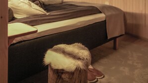 A bedroom with a bed, wooden walls, and a skylight. - Livo Arctic (Posio)