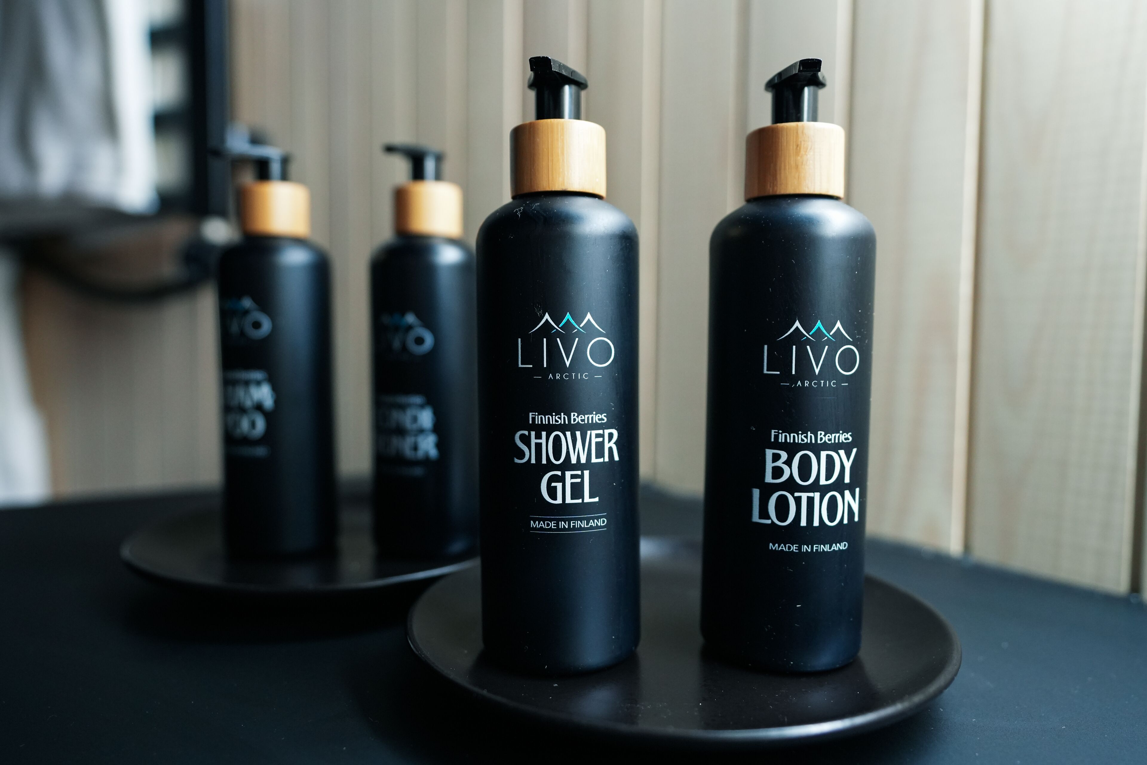 Tres botellas de gel de ducha y loción corporal LIVO Arctic sobre una bandeja negra.