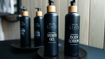 Trois flacons de gel douche et de lotion pour le corps LIVO, gamme Arctique, présentés sur un plateau noir.