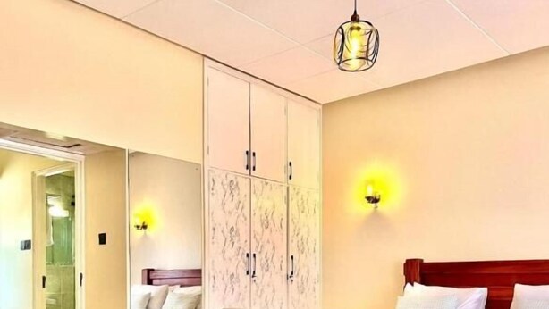 Habitación de hotel con sofá, cama, armario y una mesita redonda con botellas de agua.