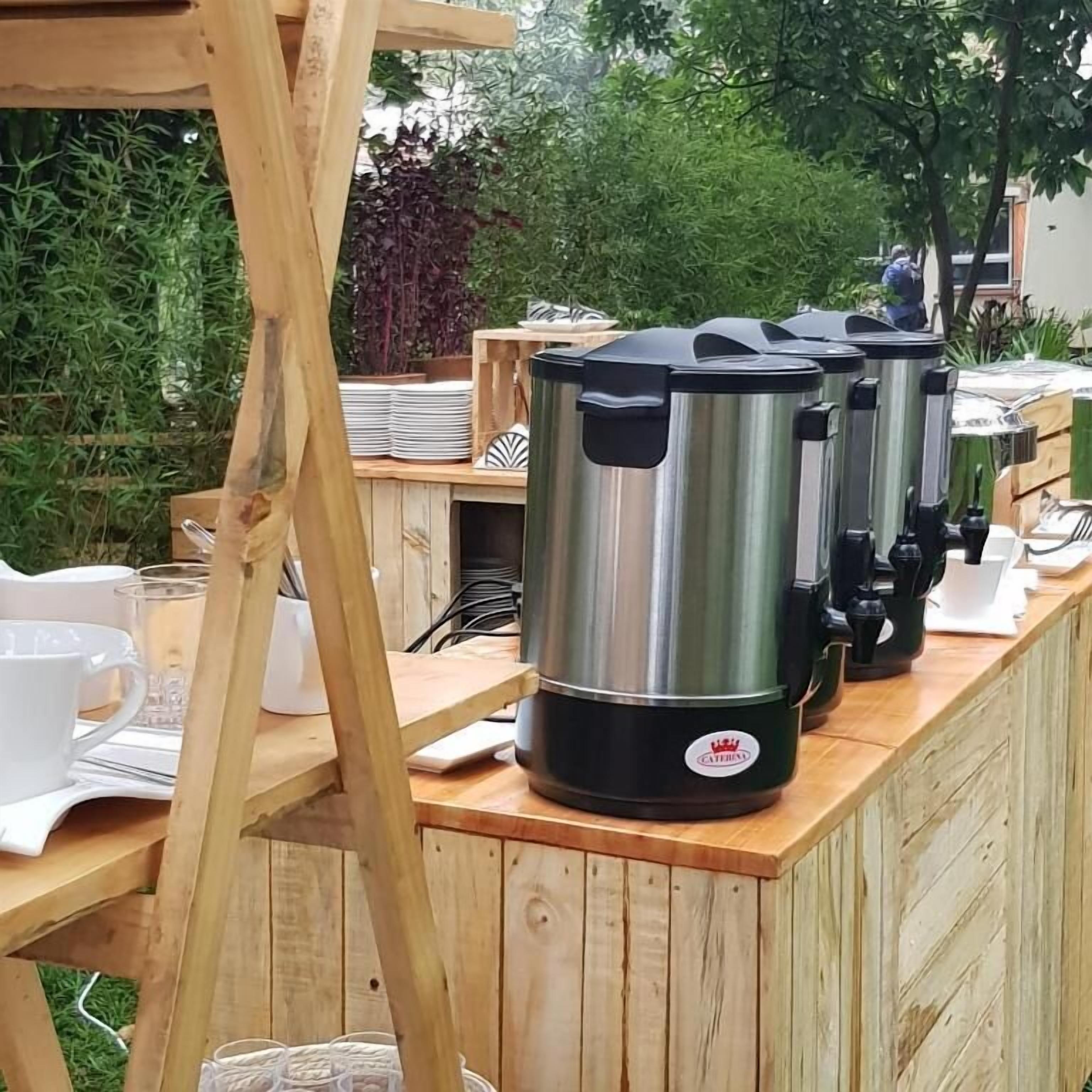 Ein hölzerner Außenbereich mit Bar, Edelstahl-Kaffeemaschinen und gestapelten weißen Tellern.