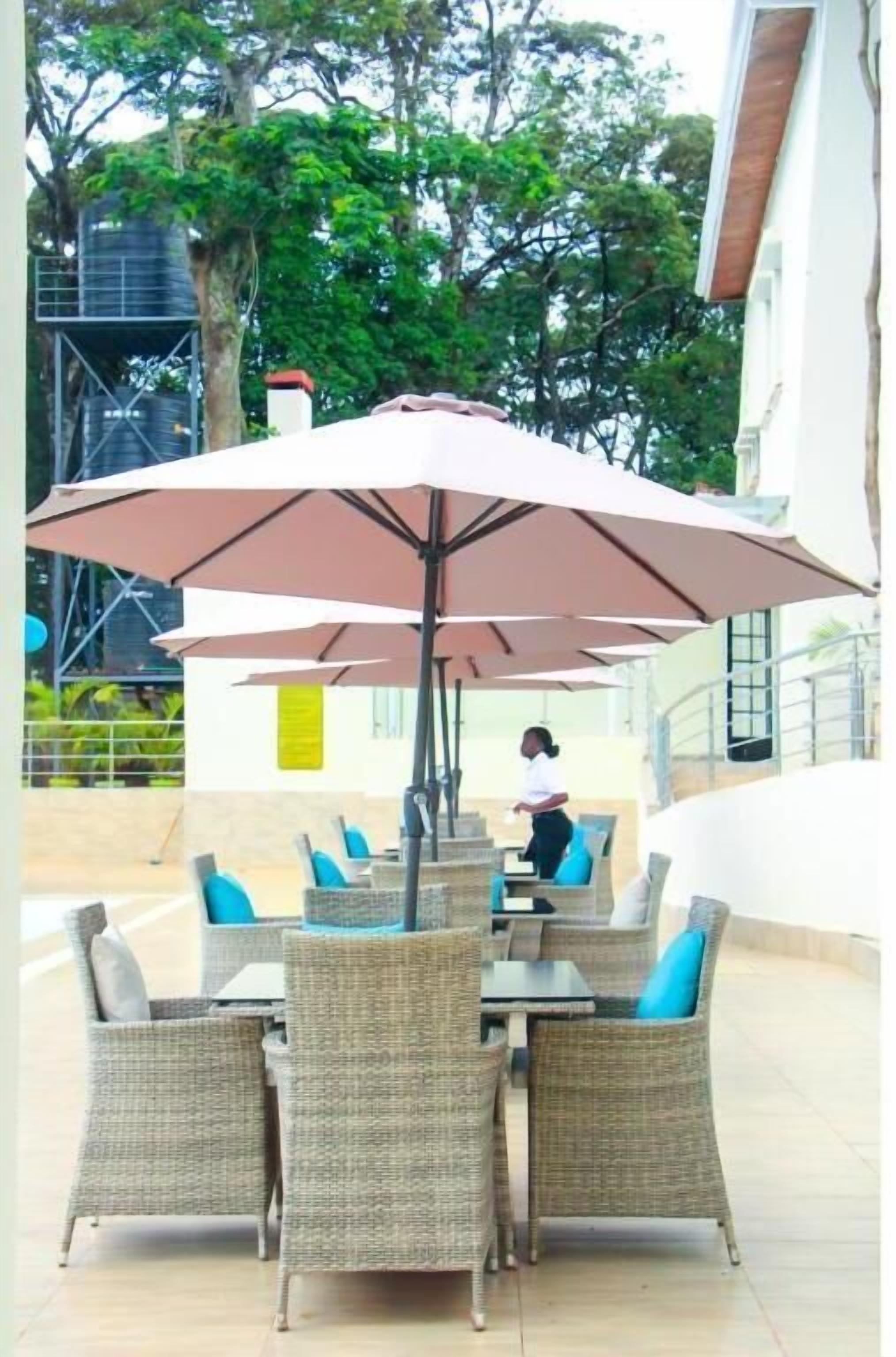 An outdoor seating area with wicker furniture and large umbrellas.