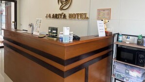 A hotel reception desk with a sign reading "J&ARIYA HOTEL" and a decorative emblem above it. - J & Ariya Hotel (Koh Samui)