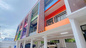 A multi-story parking garage with a modern design, featuring a series of balconies and a covered parking area. - J & Ariya Hotel (Koh Samui)