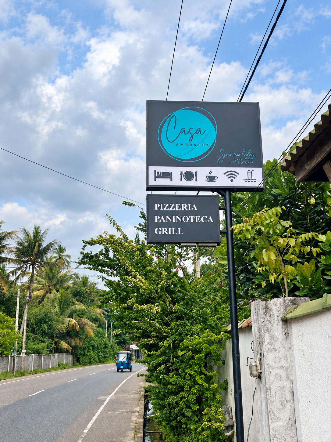 A sign for Casa Smeralda Resorts with amenities including a pizzeria, paninoteca, and grill.
