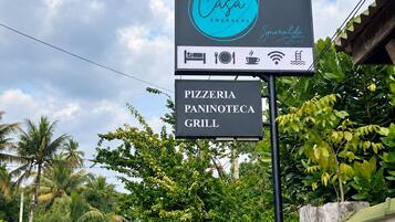 A sign for Casa Smeralda Resorts with amenities including a pizzeria, paninoteca, and grill.
