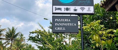 A sign for Casa Smeralda Resorts with amenities including a pizzeria, paninoteca, and grill.
