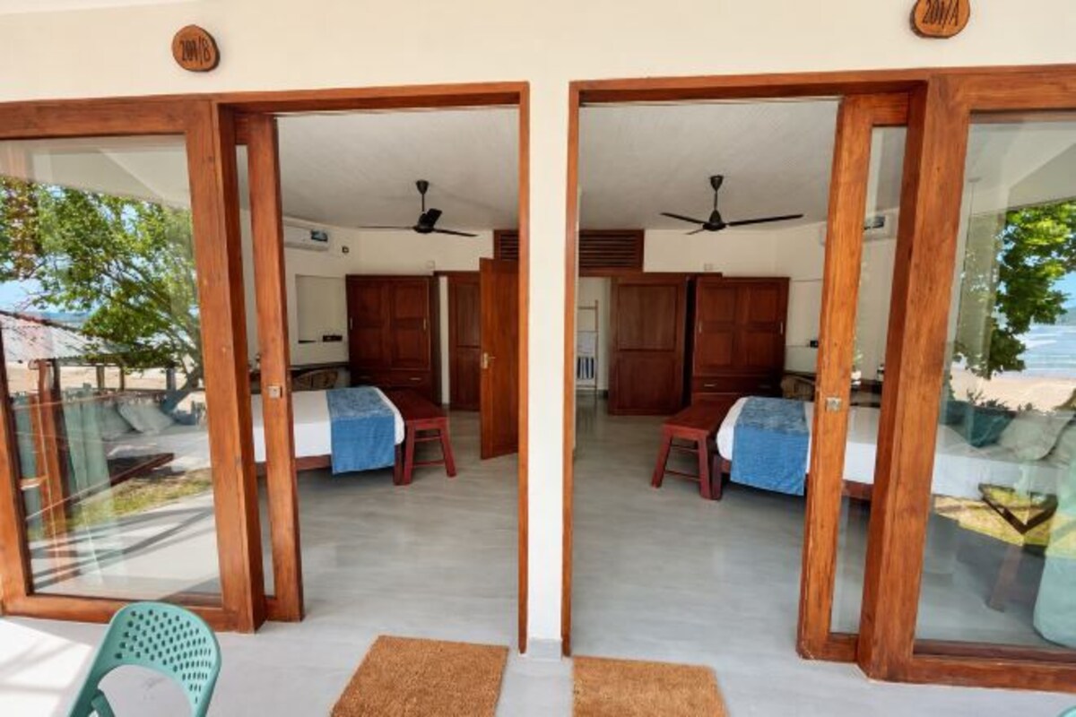 Habitación de hotel con cama, escritorio y silla. Tiene un balcón con vistas al exterior.