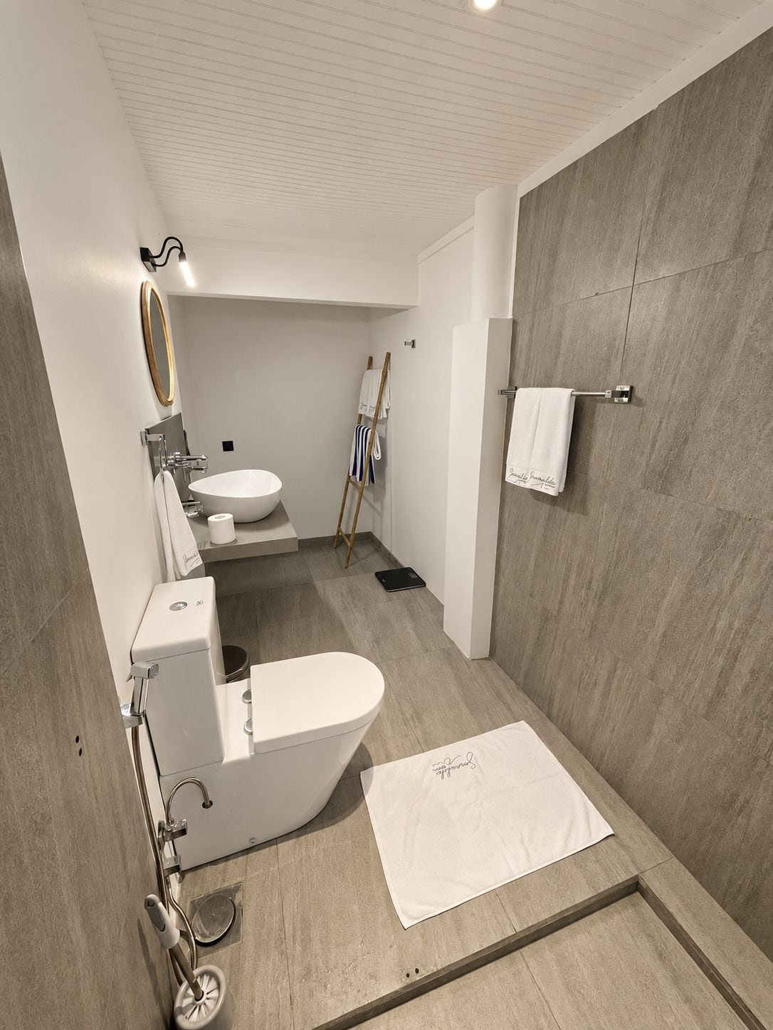 Un baño moderno con una bañera independiente, un inodoro y un lavamanos.