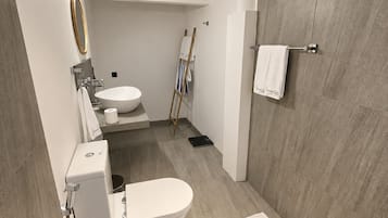 Un baño moderno con una bañera independiente, un inodoro y un lavamanos.