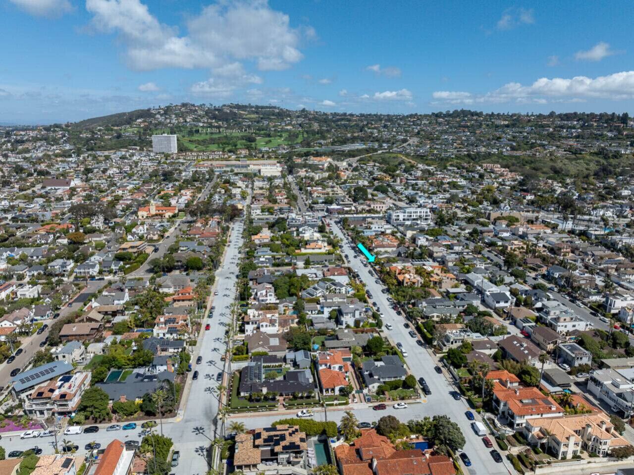 Un quartier résidentiel avec des maisons, des rues et une colline en arrière-plan.
