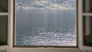 Una ventana con vista a un lago y montañas.