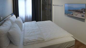 Habitación de hotel con cama, ducha y un cartel con vista a la playa.