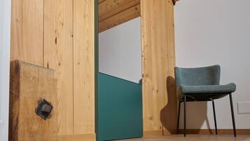 Ein Zimmer mit Holzwänden, einer türkisfarbenen Akzentwand und einem Stuhl.