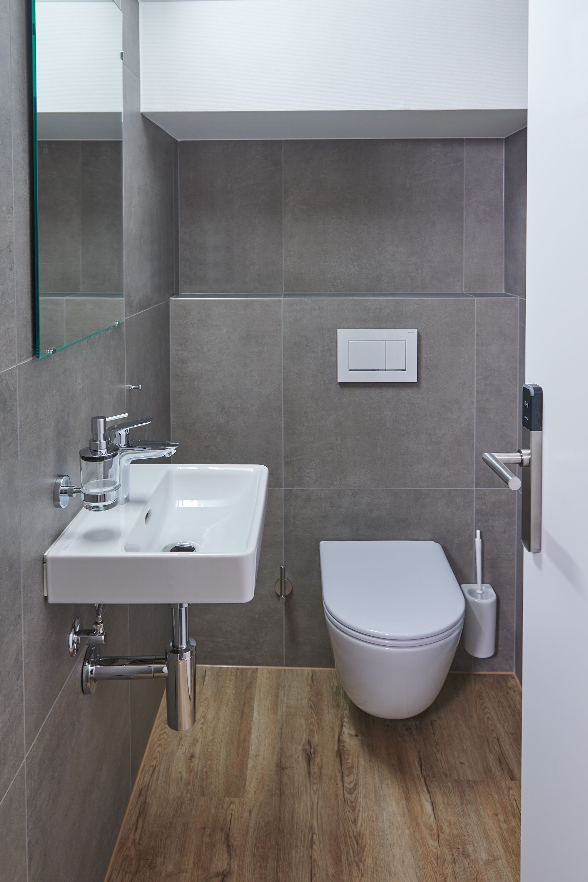 Une salle de bain moderne avec un lavabo blanc, un robinet chromé et des toilettes.