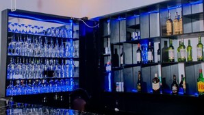 A bar area with shelves of liquor bottles and glasses. - Boutique Hotel Rwanda (Kigali)