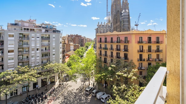 Un paisaje urbano con edificios modernos, una catedral destacada y grúas de construcción.