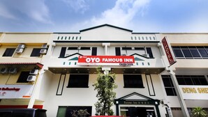 A hotel named 'OYO Famous Inn' with a prominent sign, air conditioning units, and a clear sky. - Hotel Famous Inn (Malacca City)