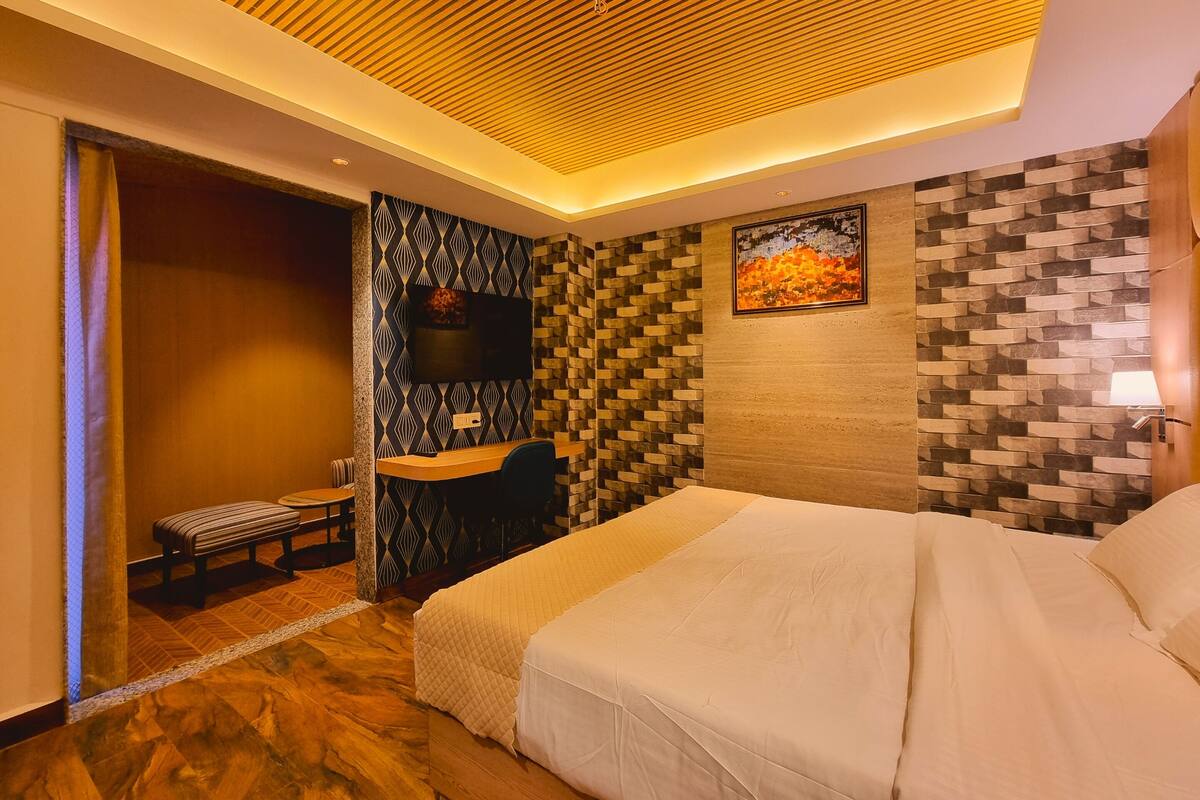 Una habitación de hotel moderna con una cama grande, un escritorio y un televisor.