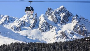 A cable car moving over a snowy mountain landscape with clear skies. - Hotel Blanche Neige   (Courchevel)