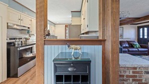 Eine Küche mit modernen Geräten, Holzbalken und einer Glasvitrine mit einem dekorativen Gegenstand.