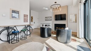 Una sala de estar moderna con chimenea, un comedor y una bicicleta estacionada junto a la ventana.