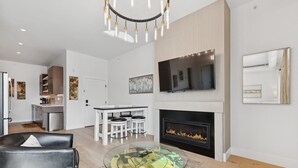 Una sala de estar moderna con chimenea, comedor y cocina.