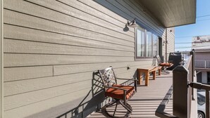 A wooden deck with outdoor furniture, including a rocking chair and a table. - Luxury Condo in Downtown with Fireplace (Whitefish)