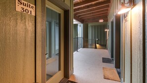 A hallway leading to a suite with a wooden ceiling and a sign indicating Suite 301.