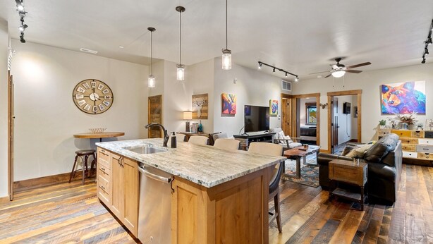 A spacious kitchen with a large island, wooden cabinets, and pendant lighting.