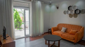 Uma sala de estar moderna com um sofá, uma mesa de centro e uma TV sobre um suporte de madeira.