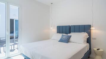 Une chambre à coucher comprenant un lit, une table de chevet et une vue sur l’extérieur, accessible par une porte coulissante.