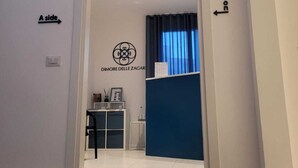 Un espace d’accueil avec un comptoir bleu, une enseigne indiquant « DIMORE DELLE ZAGAR » et une porte portant l’inscription « Côté A ».