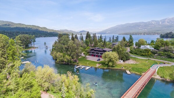 Une propriété au bord du lac, dotée d’un quai, d’un bâtiment à toit rouge et d’un pont.