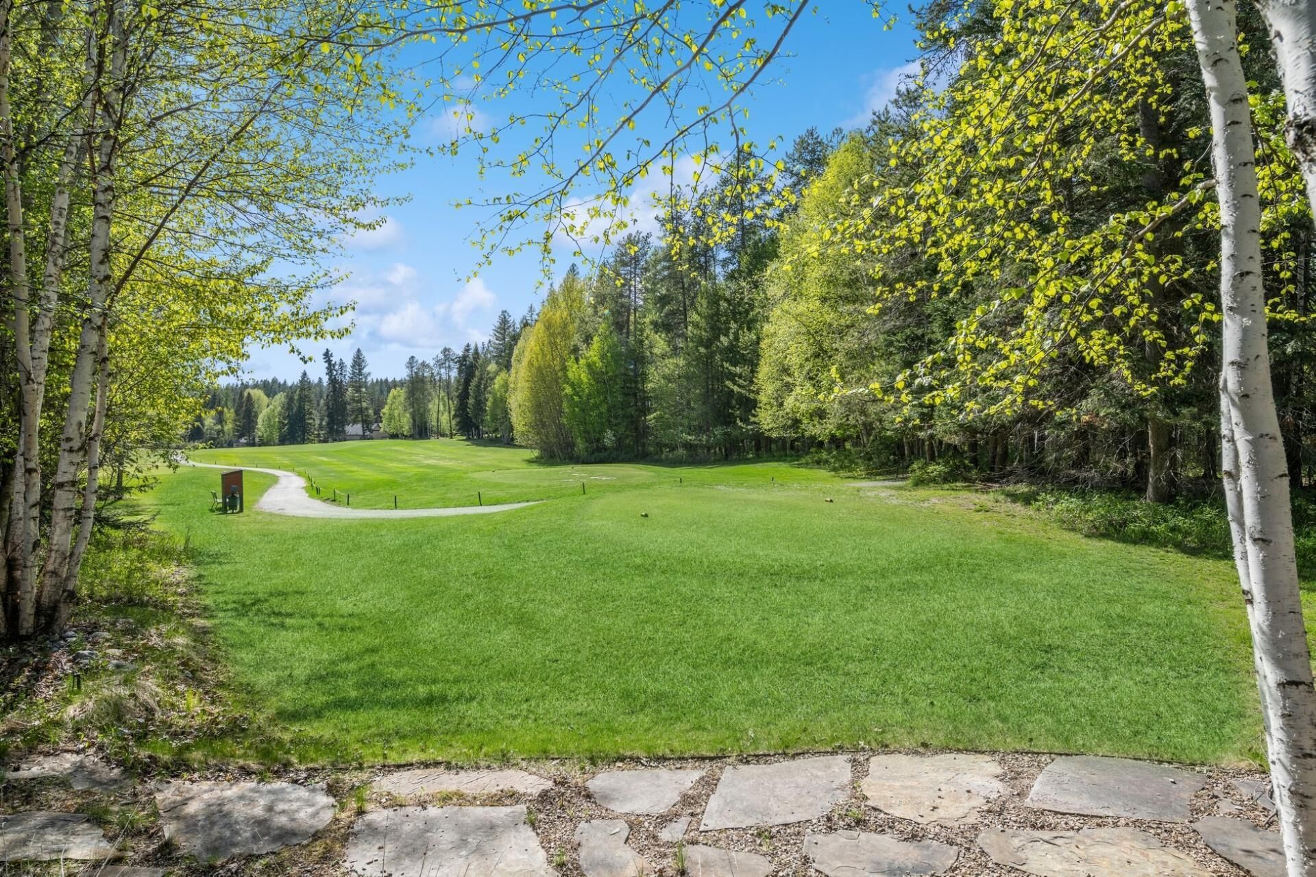 A well-maintained golf course with a stone pathway leading to the tee area.