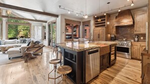 A spacious kitchen with a large island, wooden cabinets, and stainless steel appliances. - Ski-in/Ski-out Access and Private Hot Tub (Whitefish)